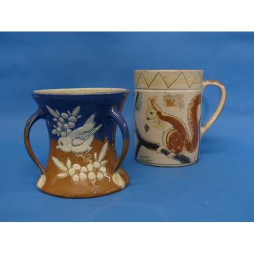 82 - A large Brannam Pottery Mug, naively adorned in sgrafitto decoration each side with red squirrels on... 