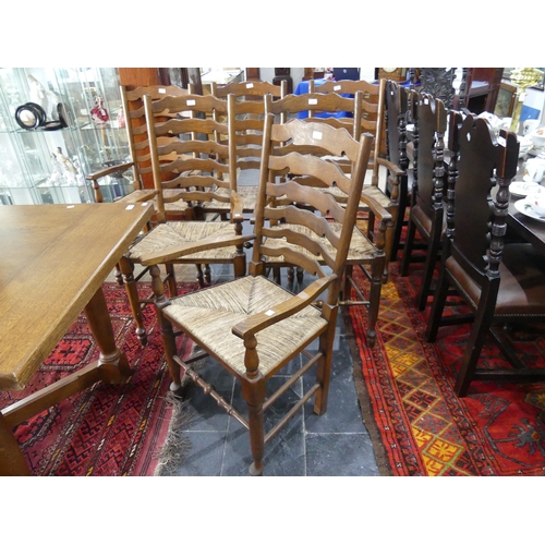 415A - A set of six oak ladder-back dining elbow chairs, with shaped splats, rush seats and turned legs joi... 