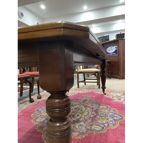 294 - An Edwardian mahogany extending Dining Table, raised on turned legs and brass caps and castors, 88in... 