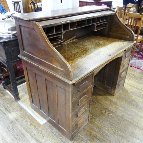 296 - An early 20thC oak Tambour-front Roll Top Desk, by M. W. Edgley & Co, the rolling top exposing f... 