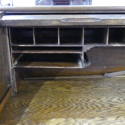 296 - An early 20thC oak Tambour-front Roll Top Desk, by M. W. Edgley & Co, the rolling top exposing f... 