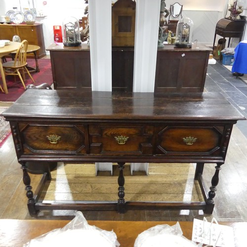 301 - A 17thC-style oak Dresser Base, the planked top above three drawers, raised on turned legs and 3/4 b... 