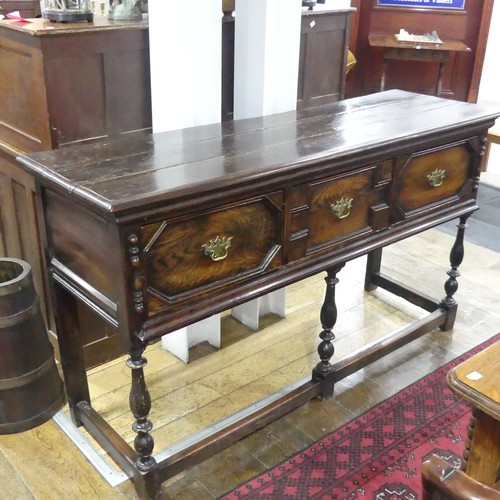 301 - A 17thC-style oak Dresser Base, the planked top above three drawers, raised on turned legs and 3/4 b... 