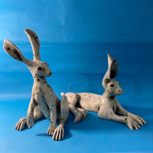 128 - A couple of contemporary raku pottery Hares, one modelled upright and the other recumbent, both with... 