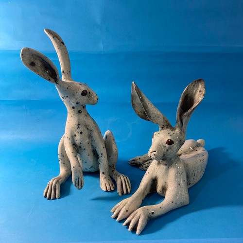 128 - A couple of contemporary raku pottery Hares, one modelled upright and the other recumbent, both with... 