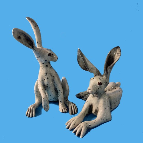 128 - A couple of contemporary raku pottery Hares, one modelled upright and the other recumbent, both with... 