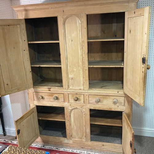 335 - A 19thC pine Housekeepers Cupboard, four cupboard doors enclosing shelves with three central drawers... 