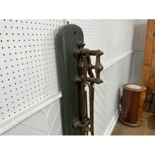 343 - A 19thC standing brass and iron hand-operated Water Pump, on green painted back board, H 155cm x W31... 