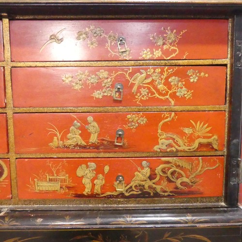 374 - An early 20thC Chinoiserie Chest on Stand, the exterior in black and gold lacquer, decorated with or... 