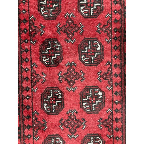 283 - Tribal Rugs: a good red ground Afghan hand knotted Runner, the whole finely woven with tekke and gul... 