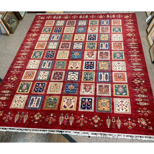 Tribal Rugs; a superb hand-knotted Zeigler carpet, with dark red ground woven all over with squares enclosing stylised floral pattterns, the tassels with coloured knots, 325cm x 250cm, in good condition.