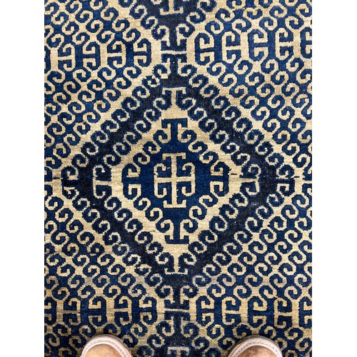 288 - Tribal Rugs; a Turkish hand-knotted rug, the dark gold ground with bold geometric designs in charcoa... 