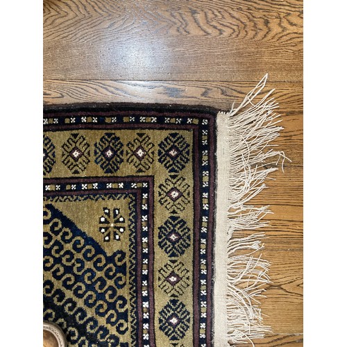 288 - Tribal Rugs; a Turkish hand-knotted rug, the dark gold ground with bold geometric designs in charcoa... 