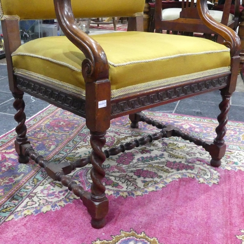 387 - An Edwardian walnut framed Armchair, with scrolling arms, embroidered mustard upholstery, raised on ... 