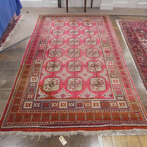 624 - Tribal Rugs; an Afghan rug, wool pile on cotton base, pink and rust ground woven with tekke and gul ... 