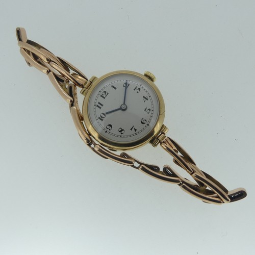 124 - A lady's 9ct gold Wristwatch, the circular silvered dial with black Arabic numerals, on 9ct gold Bri... 