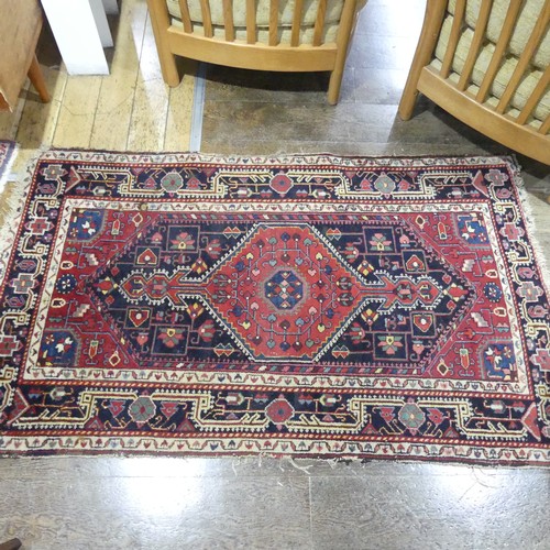 628 - Tribal Rugs; a Persian hand-knotted rug, wool pile on cotton base, overall poor condition with holes... 