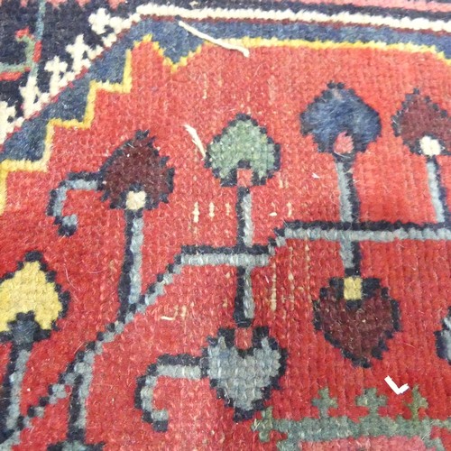 628 - Tribal Rugs; a Persian hand-knotted rug, wool pile on cotton base, overall poor condition with holes... 