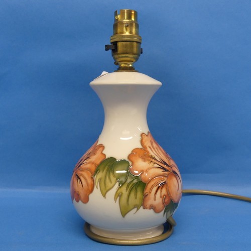 45 - A Moorcroft 'Hibiscus' pattern Lamp, and shade, in cream ground with tube lined decoration, H25cm.... 