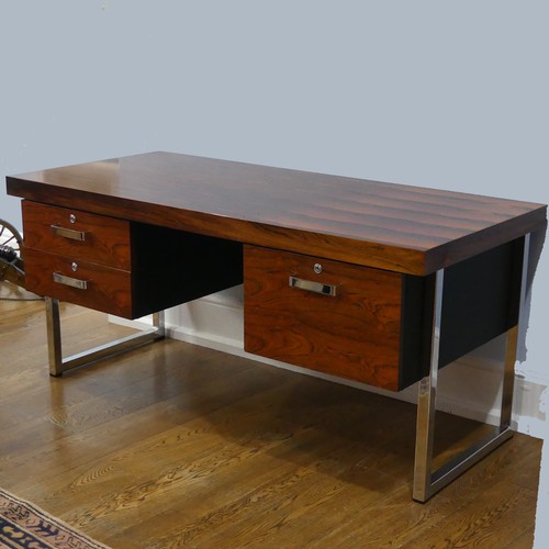 A Gordon Russell rosewood 'Prestige' Desk, designed by Trevor Chinn, circa 1970's, the veneered rectangular top upon three drawers, one with fitted interior, with chrome handles and locks, all raised on large chrome legs, W 157cm x D72.5cm x H 73cm.