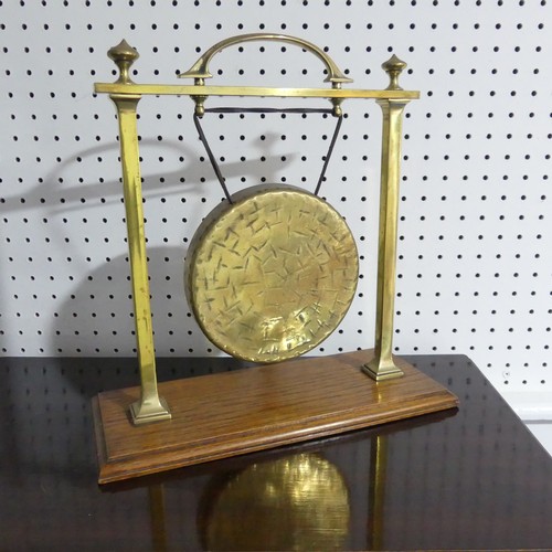 482 - An early 20thC table-top brass Gong on Stand, raised on oak plinth, with carry handle, W 36cm x H 35... 