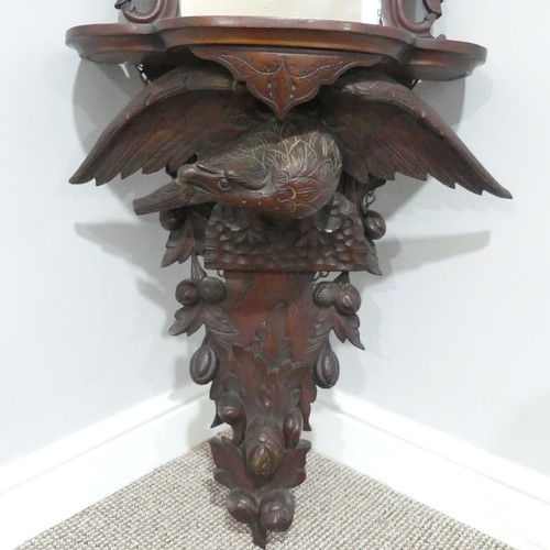 458 - A 19thC Black Forest carved Wall Bracket/Mirror, the shaped shelf on eagle supports with outstretche... 