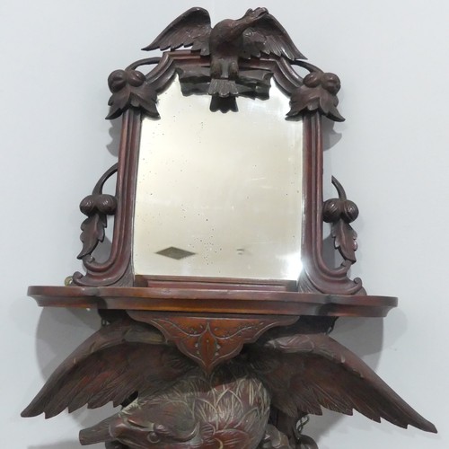 458 - A 19thC Black Forest carved Wall Bracket/Mirror, the shaped shelf on eagle supports with outstretche... 