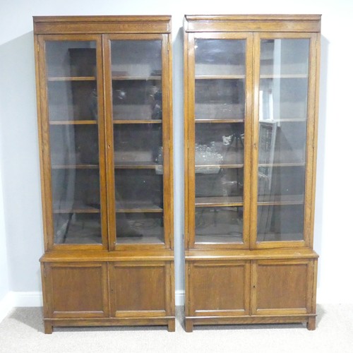 460 - A pair of early 20thC oak glazed Bookcases, each with four adjustable shelves over low cupboards, ea... 