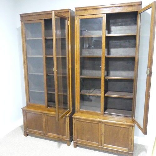 460 - A pair of early 20thC oak glazed Bookcases, each with four adjustable shelves over low cupboards, ea... 