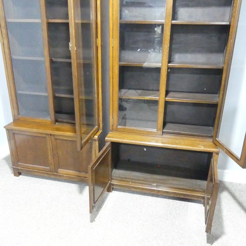 460 - A pair of early 20thC oak glazed Bookcases, each with four adjustable shelves over low cupboards, ea... 