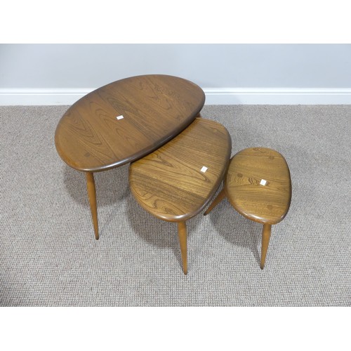 520 - An Ercol nest of three 'Pebble' Tables, of oval shape, raised on turned legs, W65cm x D44cm x H41cm... 