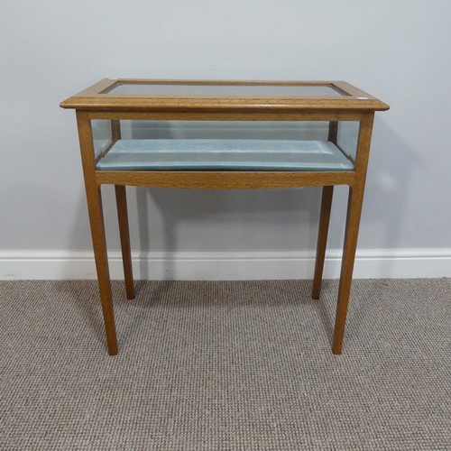 521 - A 20thC oak glazed bijouterie Table, with bevel edged glass and velvet type lining, raised on square... 