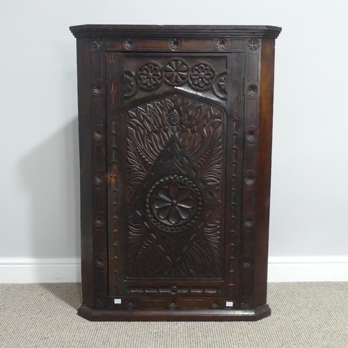 526 - A Victorian carved oak Corner Cupboard, the front heavily carved with leaf and floral decoration, th... 