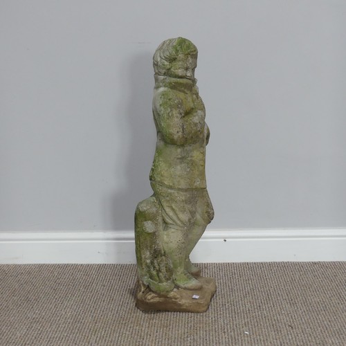 553 - Garden statuary; a reconstituted stone figure of a boy, wearing a coat leaning against a stump, H 76... 