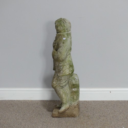 553 - Garden statuary; a reconstituted stone figure of a boy, wearing a coat leaning against a stump, H 76... 