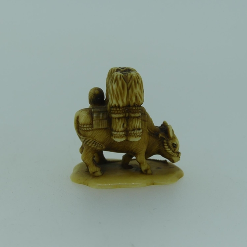 545 - An antique Japanese Ivory Netsuke, depicting a figure leading a laden water buffalo, no signature, 3... 