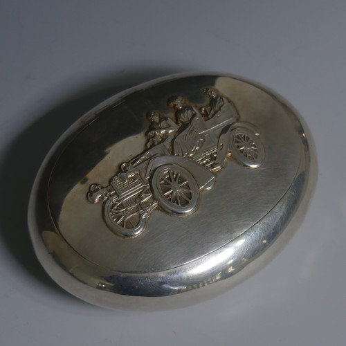 Automobilia; An Edwardian silver Tobacco Box, makers mark 'G&H', hallmarked Birmingham, 1907, of pebble form, the squeeze action hinged lid with relief decoration of an Edwardian / Brass Era motor car, with a gentleman driver and two lady passengers, 10cm wide, approx weight 3.5ozt.