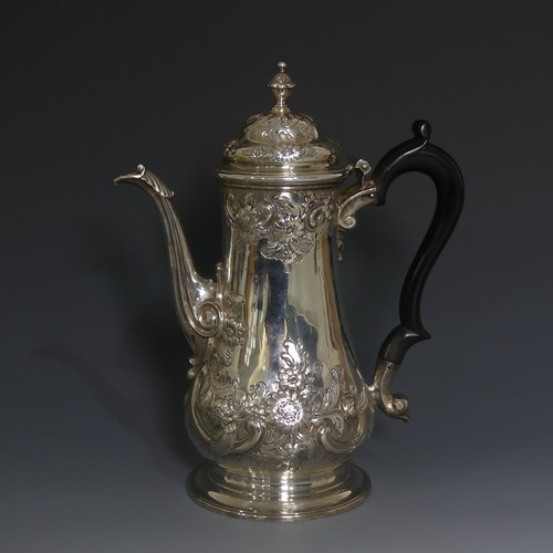 A George II silver Coffee Pot, by Thomas Whipham, hallmarked London 1755, of baluster form with scrolling foliate decoration, ebonised wooden handle, all raised on a plain spreading circular foot, the underside with initials, 23cm high, approx total weight 22.9ozt.