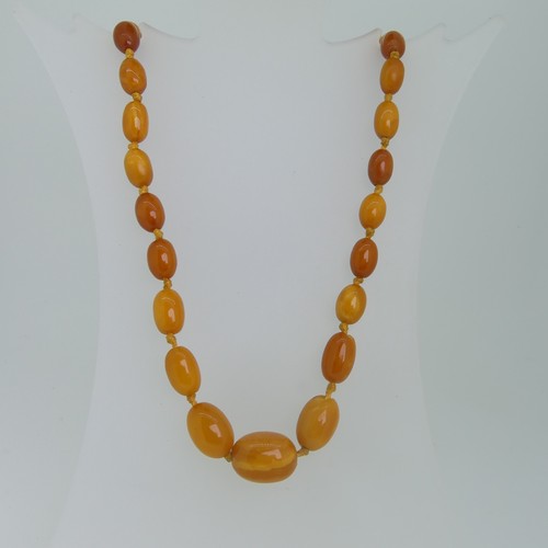 120 - A graduated butterscotch Amber Necklace, the largest oval bead 18.5mm long, overall length 52cm, gro... 