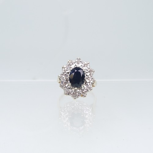 75 - A sapphire and diamond cluster Ring, the oval facetted sapphire claw set above a surround of illusio... 