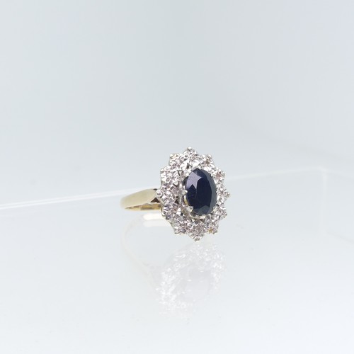 75 - A sapphire and diamond cluster Ring, the oval facetted sapphire claw set above a surround of illusio... 