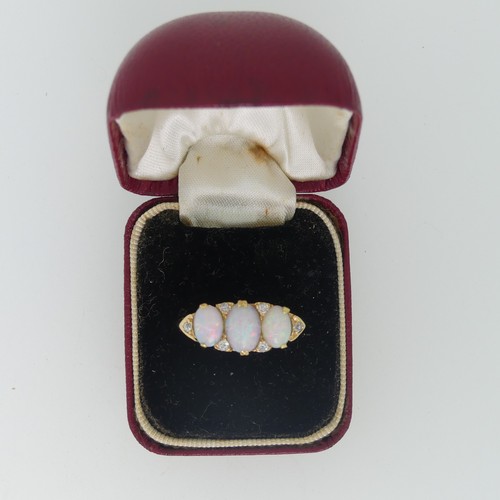 98 - An early 20thC graduated three stone opal Ring, each with two diamond points set vertically  between... 