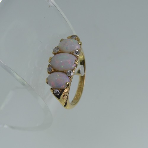 98 - An early 20thC graduated three stone opal Ring, each with two diamond points set vertically  between... 