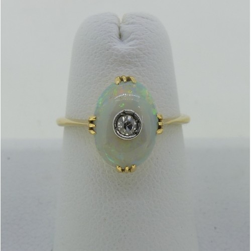 86 - A small opal and diamond Ring, the oval opal 10.5mm x 7.5mm, set with a diamond point centre, all mo... 