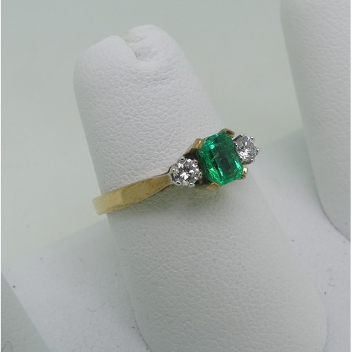 87 - An emerald and diamond three stone Ring, the central emerald cut emerald, c. 5mm x 3.6mm, with a cir... 