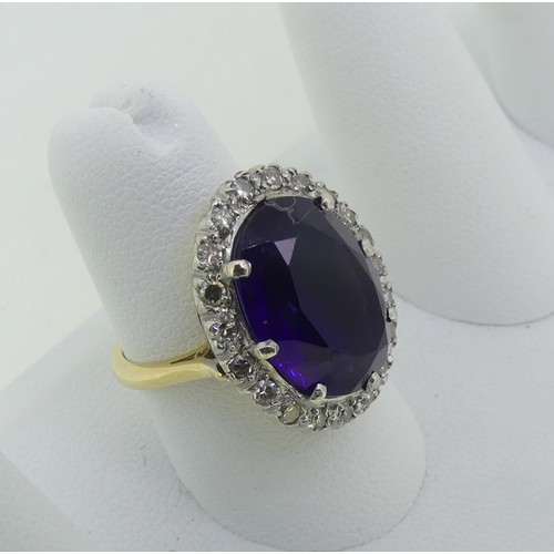 106 - An amethyst and diamond Dress Ring, the oval facetted amethyst surrounded by twenty small diamond po... 