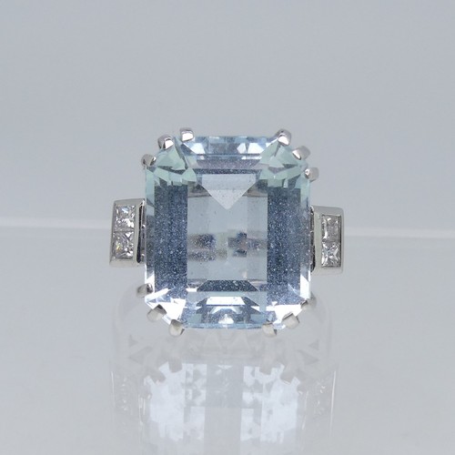 105 - An aquamarine and diamond Dress Ring, the step cut aquamarine 13.75mm x 11.75mm with two diamonds on... 