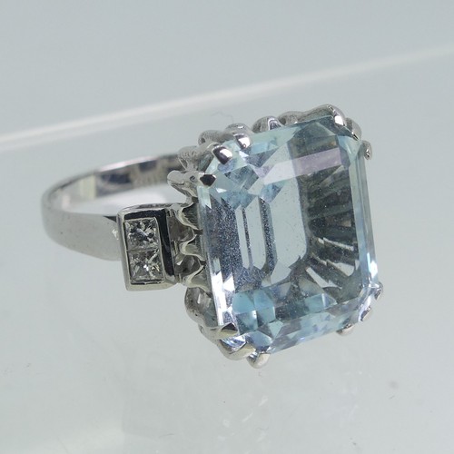 105 - An aquamarine and diamond Dress Ring, the step cut aquamarine 13.75mm x 11.75mm with two diamonds on... 