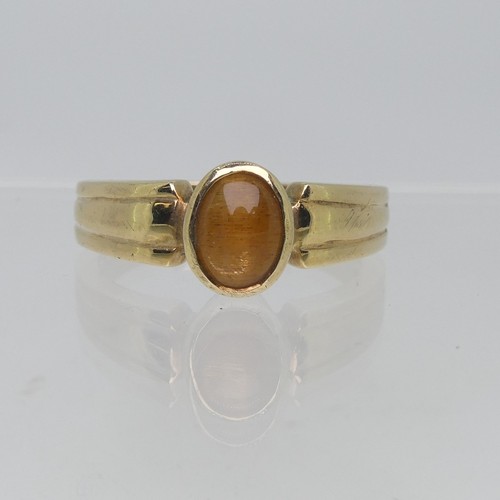 74 - A 9ct yellow gold Signet Ring, collet set with an oval Tiger's Eye, Size T, 4.5g.