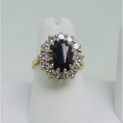 80 - A sapphire and diamond Cluster Ring, the oval facetted sapphire approx. 10mm x 6.8mm, surrounded by ... 